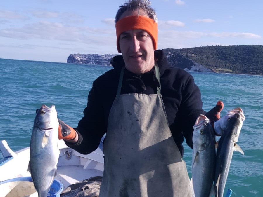 Elia con il pescato del giorno davanti al promontorio di Peschici